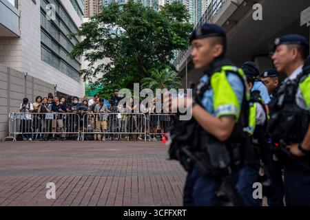 Verteidigt in Hongkong 47 Demokraten-Fall Berufung Verurteilung und Verurteilung Polizeibeamte, die neben Medienreportern in einer von der Polizei am 14. Juli 2025 vor den Gerichten der West Kowloon Magistrates in Hongkong ausgewiesenen Pressezone Wache halten. Zwölf Aktivisten aus Hongkong, die in dem bahnbrechenden Fall der demokraten 47 verurteilt und verurteilt wurden, legten heute vor einem Gericht in Hongkong Berufung gegen ihre Verurteilungen und Gefängnisstrafen gegen Subversion ein. Sie wurden verhaftet und wegen Verschwörung zur Begehung von Subversion Anfang 2021 wegen Teilnahme an den Vorwahlen des pro-demokratischen Lagers angeklagt. Stockfoto