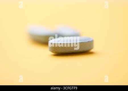 Multivitamintabletten auf hellem Papierhintergrund. Nahaufnahme. Kopierbereich Stockfoto