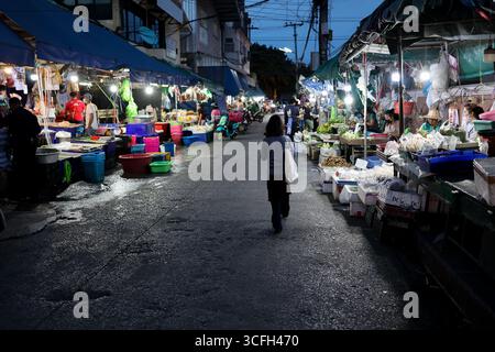 Abendliche Marktszene mit zahlreichen Händlern und hellen, bunten Lichtern. Stockfoto