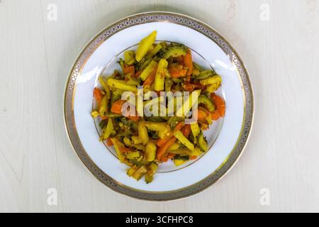 Kartoffeln-, Karotten- und Bitterkürbis-Krapfen auf einem weißen Teller. Diese Gemüsesorten werden gehackt, gemischt und dann gebraten. Dieses Bangladeschische Gericht ist ein Heilmittel Stockfoto