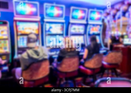 Spielautomaten mit Spielern in einem farbenfrohen Casino-Interieur Stockfoto