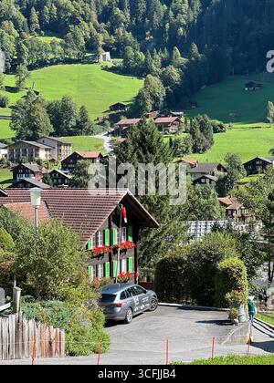 Traditionelle Schweizer Chalets im Lauterbrunnental, umgeben von grünen Wiesen und alpiner Landschaft, Schweiz. Stockfoto