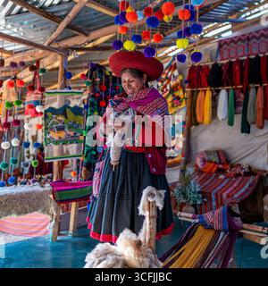 Andenfrau webt bunte Textilien in Cusco, Peru. Traditionelles Kunsthandwerk mit Wolle, leuchtenden Farben und authentischem Kulturerbe. Stockfoto