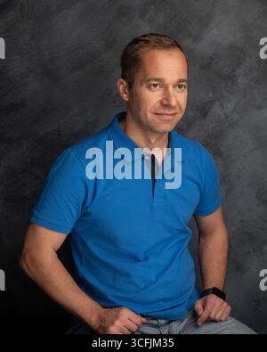 Lächelnder Mann im blauen Poloshirt-Studio-Porträt Stockfoto
