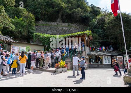 Touristen stehen am Eingang von Machu Picchu in Peru an und zeigen den massiven Besucherstrom der Inka-Zitadelle, die zum UNESCO-Weltkulturerbe gehört. Stockfoto