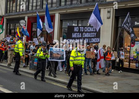 Hong Kongers und Mitglieder der chinesischen Diaspora versammelten sich in Zentral-London, um gegen den geplanten Bau einer chinesischen Mega-Botschaft zu protestieren. Demonstranten äußerten Bedenken über Pekings Einfluss und sprachen Menschenrechtsfragen an und forderten die britische Regierung auf, das Projekt einzustellen. Stockfoto