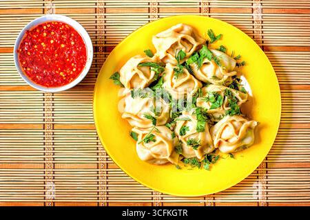 Ein Teller asiatischer Mantys und ein Pfeffer-Gewürz. Stockfoto
