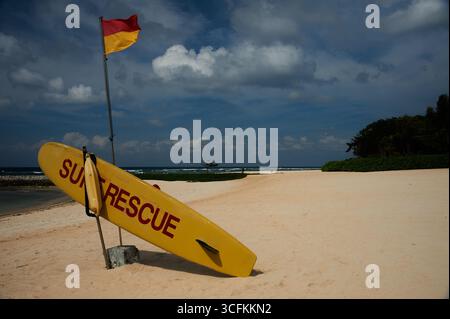 Surfbretter und rote und gelbe Warnflaggen an einem Sandstrand in Bali, Indonesien Stockfoto