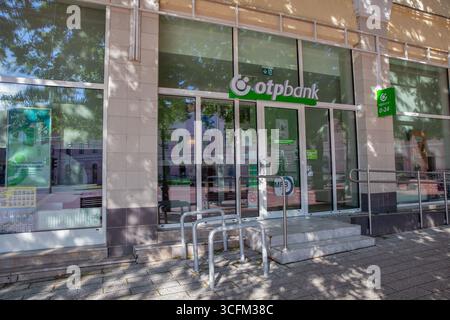 Nagykanizsa, Ungarn - 18. Mai 2025: Moderne OTP-Bank-Filiale mit großen Glasfenstern, grünem Firmenlogo und Fahrradständern aus Metall auf der urb Stockfoto