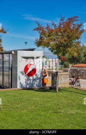 Tar, Kroatien - 29. Mai 2025: Ein Mann benutzt an einem sonnigen Tag einen Geldautomaten von Zagrebacka Banka. Die helle Szene umfasst grünes Gras, Bäume und einen fahrradpark Stockfoto