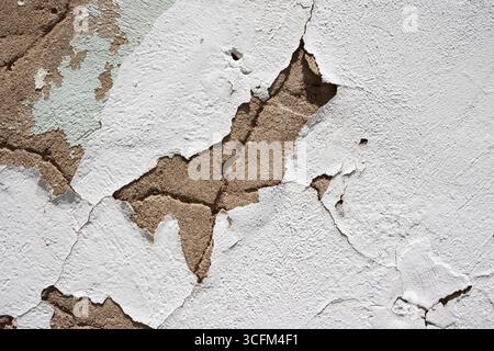 Textur der abblätternden weißen Farbe auf einer verwitterten alten Rissbetonwand. Aufgenommen in Centralia, Missouri, USA. Stockfoto