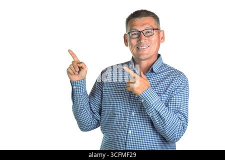 Hübscher asiatischer Mann mittleren Alters mit einer Brille, die lächelt und Zeigefinger auf die Seite zeigt, isoliert auf weißem Hintergrund. Stockfoto