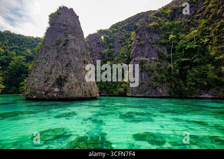 Balbulol Island liegt im Südosten von Misool. Auf dieser Insel gibt es fünf hohe Klippen, die einen Kegel bilden, in einer Reihe an der vorderen Linie des blauen Wassers Stockfoto