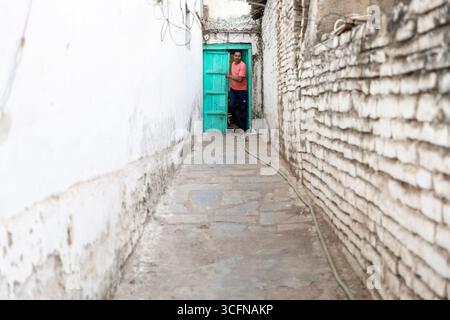 Mann öffnet Tür in der Altstadt von Shivrinarayan, wichtige Wallfahrtsstätte für hindus, alte historische Häuser in Chhattisgarh in Indien Stockfoto