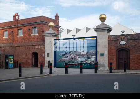 Tor und Eingang zu Portsmouth Historic Dockyard, mit einem Luftbild der Gegend, um den Besuchern zu zeigen, was sie sehen werden. August 2025. Stockfoto