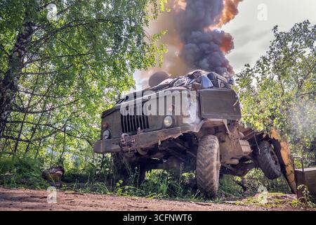 Krieg in der Ukraine. Rauchen von Militärfahrzeugen, Logistikstörungen. Militärfahrzeug in Rauch nach Explosion im Konflikt in der Ukraine. Stockfoto