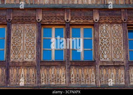 Fenster auf der Holzfassade eines rustikalen Hauses aus Holzbalken in einem Bergkarpaten Dorf, Westukraine, Europa, Nahaufnahme Stockfoto
