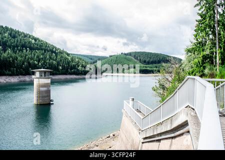 Entdecken Sie die ruhige Schönheit des Söse-Damms im deutschen Harz. Dieses Bild fängt den ruhigen See und die üppige Waldlandschaft ein. Stockfoto