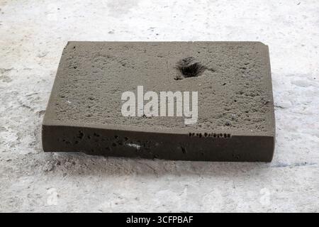 Ein altes, gebrauchtes Stück Schwammschaum sitzt auf einem Betondach. Trotz seines Alters ist dieses vielseitige Material immer noch für Isolierung, Dämpfung oder geeignet Stockfoto