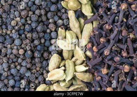 Nahaufnahme der Textur aus schwarzem Pfeffer, Cardamom und Nelken. Aromatische und aromatische Gewürze. Stockfoto