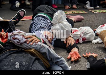 Bandung, Indonesien. August 2025. Demonstranten spielen Theater während einer Solidaritätsaktion für Palästina in Bandung, West-Java, Indonesien am 24. August 2025. In der Kundgebung forderten sie ein sofortiges Ende des Krieges und der Gewalt gegen Zivilisten in Palästina und forderten alle indonesischen Bürger auf, israelische Produkte zu boykottieren und die Gewalt gegen Journalisten im Gazastreifen zu beenden. (Foto: Dimas Rachmatsyah/SIPA USA) Credit: SIPA USA/Alamy Live News Stockfoto