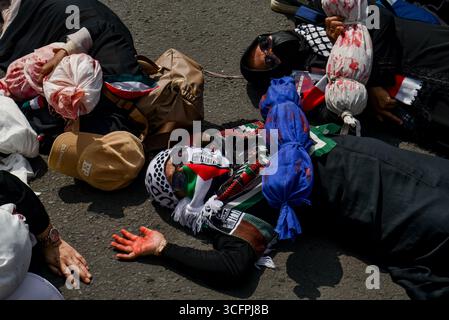 Bandung, Indonesien. August 2025. Demonstranten spielen Theater während einer Solidaritätsaktion für Palästina in Bandung, West-Java, Indonesien am 24. August 2025. In der Kundgebung forderten sie ein sofortiges Ende des Krieges und der Gewalt gegen Zivilisten in Palästina und forderten alle indonesischen Bürger auf, israelische Produkte zu boykottieren und die Gewalt gegen Journalisten im Gazastreifen zu beenden. (Foto: Dimas Rachmatsyah/SIPA USA) Credit: SIPA USA/Alamy Live News Stockfoto
