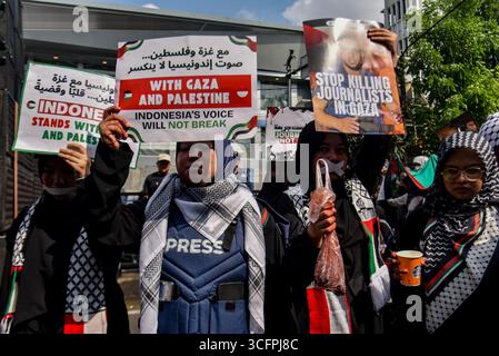Bandung, Indonesien. August 2025. Demonstranten halten Plakate während einer Solidaritätsaktion für Palästina in Bandung, West-Java, Indonesien am 24. August 2025. In der Kundgebung forderten sie ein sofortiges Ende des Krieges und der Gewalt gegen Zivilisten in Palästina und forderten alle indonesischen Bürger auf, israelische Produkte zu boykottieren und die Gewalt gegen Journalisten im Gazastreifen zu beenden. (Foto: Dimas Rachmatsyah/SIPA USA) Credit: SIPA USA/Alamy Live News Stockfoto