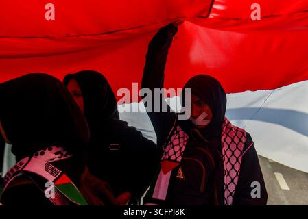 Bandung, Indonesien. August 2025. Demonstranten halten eine große indonesische Flagge während einer Solidaritätsaktion für Palästina in Bandung, West-Java, Indonesien am 24. August 2025. In der Kundgebung forderten sie ein sofortiges Ende des Krieges und der Gewalt gegen Zivilisten in Palästina und forderten alle indonesischen Bürger auf, israelische Produkte zu boykottieren und die Gewalt gegen Journalisten im Gazastreifen zu beenden. (Foto: Dimas Rachmatsyah/SIPA USA) Credit: SIPA USA/Alamy Live News Stockfoto
