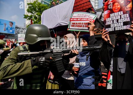Bandung, Indonesien. August 2025. Ein Demonstrant, der am 24. August 2025 in Bandung, West-Java, Indonesien, eine nachgebildete Armee-Uniform während einer Solidaritätsaktion für Palästina benutzte. In der Kundgebung forderten sie ein sofortiges Ende des Krieges und der Gewalt gegen Zivilisten in Palästina und forderten alle indonesischen Bürger auf, israelische Produkte zu boykottieren und die Gewalt gegen Journalisten im Gazastreifen zu beenden. (Foto: Dimas Rachmatsyah/SIPA USA) Credit: SIPA USA/Alamy Live News Stockfoto