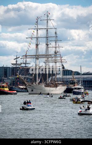 Amsterdam Niederlande 24. August 2025 das Finale des fünfjährlichen Sail Tall Ships-Events ist das sogenannte Sail-Out. Der het ij Wasserweg im Zentrum von Amsterdam ist ein Block mit kleinen Booten, während die großen Schiffe ihren Weg zum Noordzeekanaal und danach zur Nordsee machen. Aufgrund des Westwindes und der Westrichtung halten viele der Schiffe ihre Segel gerollt. Der Shabab Oman II führt den Weg. HAVEN, Sail25, People, Niederländisch, Nederland, Holland, Besucher, Stockfoto