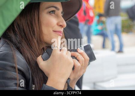 Seitenprofil einer Touristenfrau mit Kamera in einer Menschenmenge Stockfoto