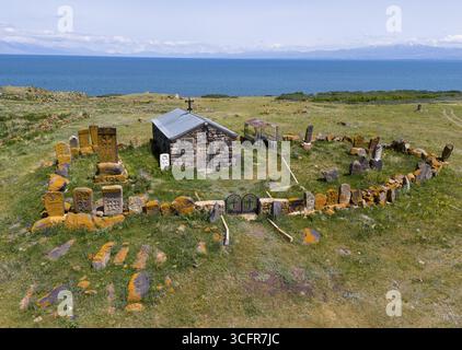 Kleines Steinhaus umgeben von alten Grabsteinen mit Blick auf das Meer und die fernen Berge, Blick aus der Vogelperspektive, Kapelle des Heiligen Kreuzes, Sarukhan, See Sev Stockfoto