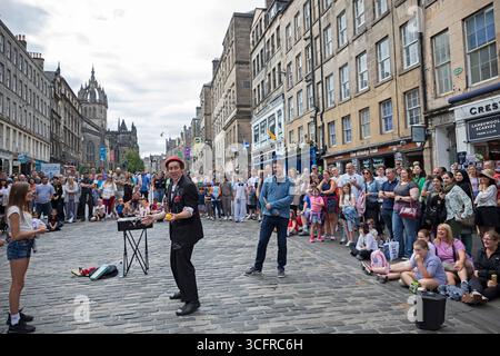 Royal Mile, Edinburgh Festival Fringe, Schottland, Großbritannien. August 2025. Letztes Wochenende der Unterhaltung auf der High Street. Die Menschenmassen waren sehr überschaubar, wie sie die meisten Tage während des Arts Festivals auf der Royal Mile waren. Straßenkünstler äußerten, dass sie mit dem Publikum, das sie gewinnen konnten, und der daraus resultierenden Vergütung für ihre Performance zufrieden waren. Matt von Trap Magier unterhält die Menge. Quelle: Arch White/Alamy Live News. Stockfoto