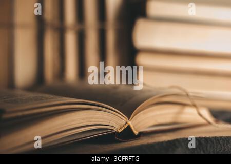 Alte, antiquarische Bücher stapeln sich auf Holztisch. Historische Bücher über Astrologie, Astronomie, Psychologie, Kunst Stockfoto