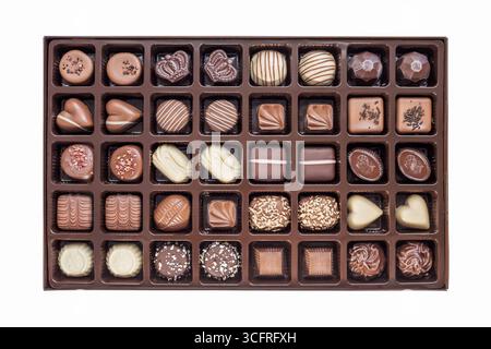 Ein Set festlicher Schokoladenbonbons in verschiedenen Formen und Designs in einer Box auf weißem Hintergrund. Blick von oben. Draufsicht Stockfoto