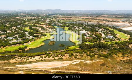 Ein sich schlängelnder See schlängelt sich durch ein gehobenes Viertel mit Golfplätzen. Stockfoto