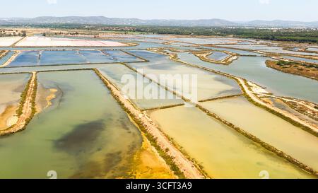 Eine komplexe Anordnung von Salinen und Wasserkanälen bildet eine farbenfrohe Landschaft. Stockfoto