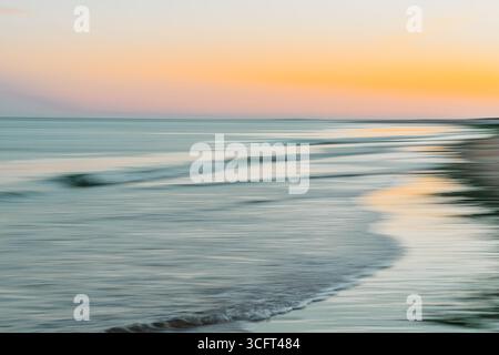 Ein weicher Fokus auf eine einzelne Welle in einer farbenfrohen Meereslandschaft bei Sonnenuntergang. Stockfoto