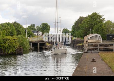 Ein Segelboot, das durch die Banavie Swing Bridge fährt, während es den Caledonian Canal am Fuße der Neptuntreppe in der Nähe von Fort William verlässt Stockfoto