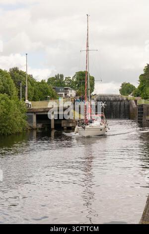 Ein Segelboot, das durch die Banavie Swing Bridge fährt, während es den Caledonian Canal am Fuße der Neptuntreppe in der Nähe von Fort William verlässt Stockfoto