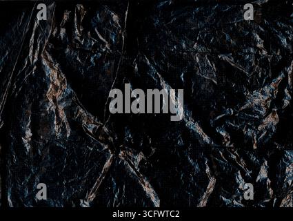 Altes Blatt. Faltiges schwarzes Papier. Zerknitterter, rauer Kunststoff-Grunge-leerer abstrakter Hintergrund. Dunkle Distress Flare verschwimmen die veraltete Textur. Stockfoto