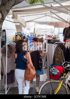 Cremona, Italien - 23. August 2025 Besucher stöbern in der Sonne an einem Marktstand im Freien im historischen Stadtzentrum von Cremona Lombardei Italien Stockfoto