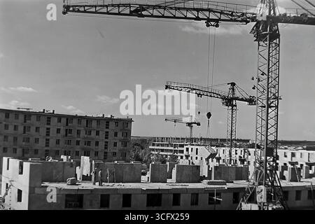 Panoramablick auf den großformatigen Bau eines neuen Paneelmikroraions in Sloviansk, ukrainische SSR, 1970er Jahre, mit schienenmontierten Turmdrehkranen und Montagearbeitern, die die industrielle Wohnungsentwicklung und das friedliche Wachstum des Donbas während der Stagnation symbolisieren Stockfoto