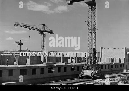 Panoramablick auf den großformatigen Bau eines neuen Paneelmikroraions in Sloviansk, ukrainische SSR, 1970er Jahre, mit schienenmontierten Turmdrehkranen und Montagearbeitern, die die industrielle Wohnungsentwicklung und das friedliche Wachstum des Donbas während der Stagnation symbolisieren Stockfoto