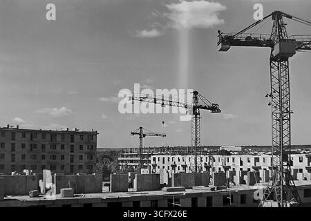 Panoramablick auf den großformatigen Bau eines neuen Paneelmikroraions in Sloviansk, ukrainische SSR, 1970er Jahre, mit schienenmontierten Turmdrehkranen und Montagearbeitern, die die industrielle Wohnungsentwicklung und das friedliche Wachstum des Donbas während der Stagnation symbolisieren Stockfoto