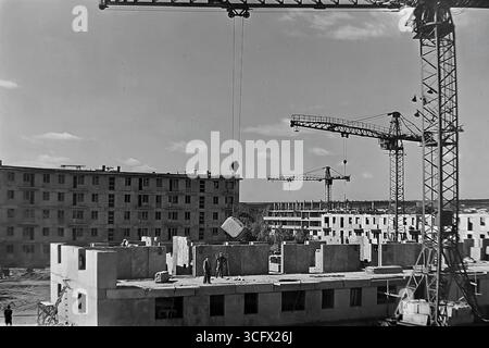 Panoramablick auf den großformatigen Bau eines neuen Paneelmikroraions in Sloviansk, ukrainische SSR, 1970er Jahre, mit schienenmontierten Turmdrehkranen und Montagearbeitern, die die industrielle Wohnungsentwicklung und das friedliche Wachstum des Donbas während der Stagnation symbolisieren Stockfoto