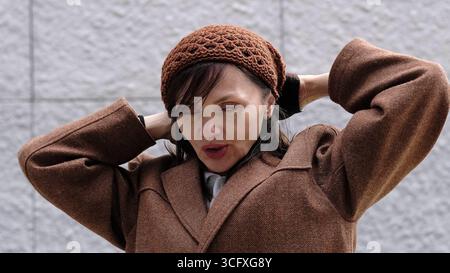 Eine elegante Seniorin strahlt Charme und Selbstbewusstsein aus, gekleidet in einem geschmackvollen Outfit. Ihr komponiertes Auftreten spiegelt die Stärke und Weisheit des Alters wider Stockfoto