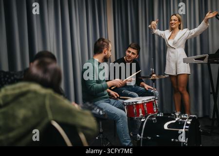 Musikalische Bandprobe mit Dirigentin in einem modernen Übungsstudio Stockfoto