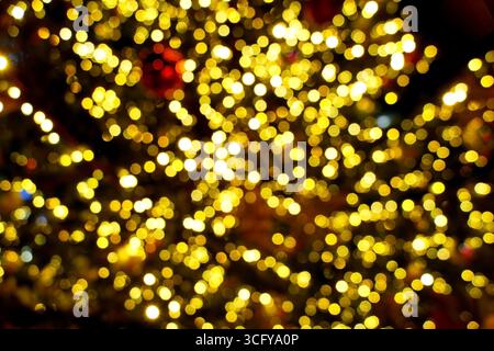 Goldener Weihnachtsbaum Lichter Bokeh - Hintergrund mit warmgelber Beleuchtung. Unscharfe Feenlichter sorgen für Winterstimmung Stockfoto