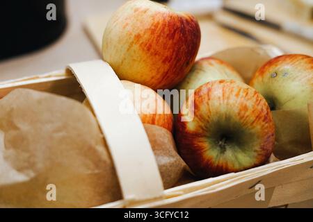 Eine üppige Sammlung frischer Äpfel, angeordnet in einem Holzkorb Stockfoto